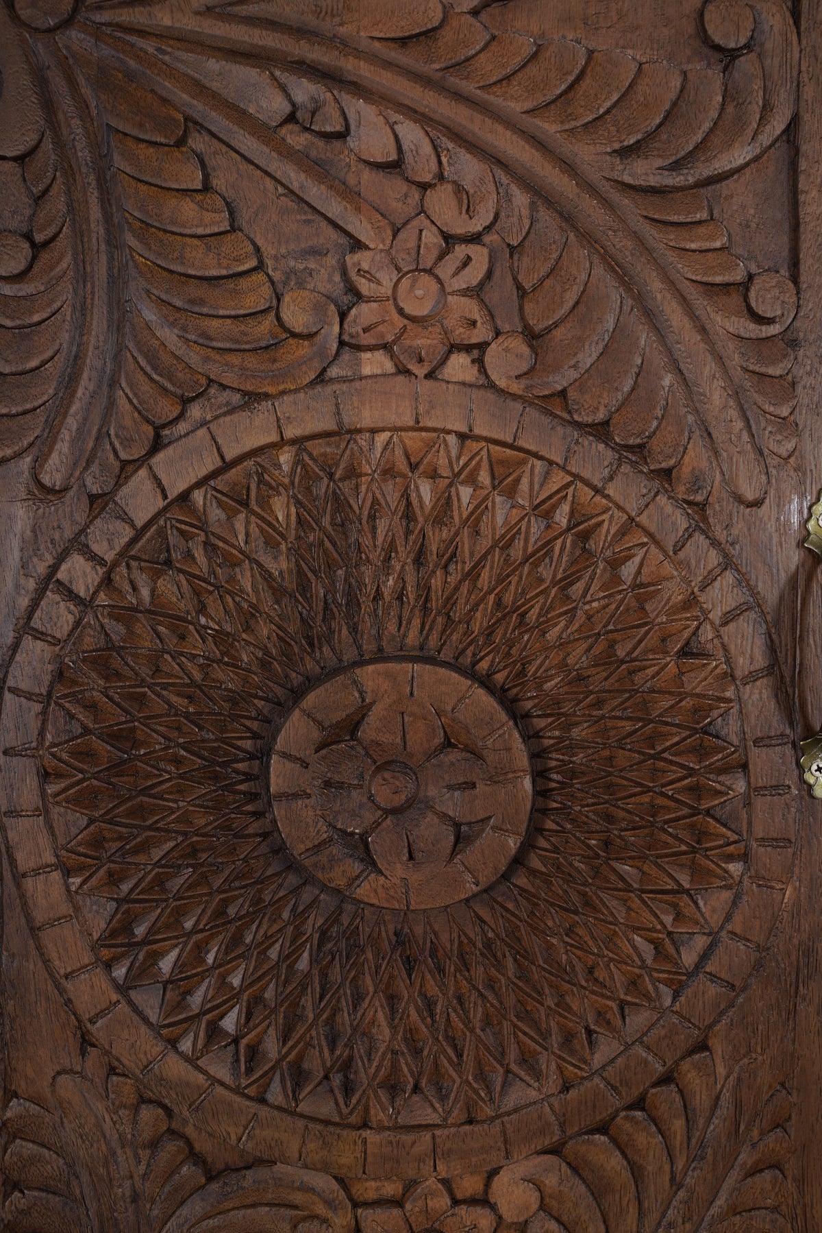 Sienna armoire door, close-up of hand-carved sunburst medallion in mango wood