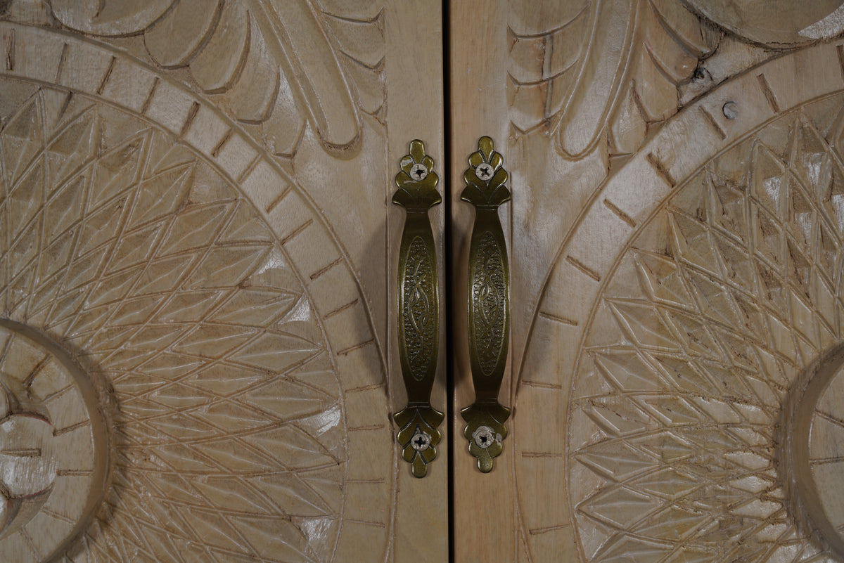 Birch armoire, close-up of antique-brass door pulls on natural beige mango wood
