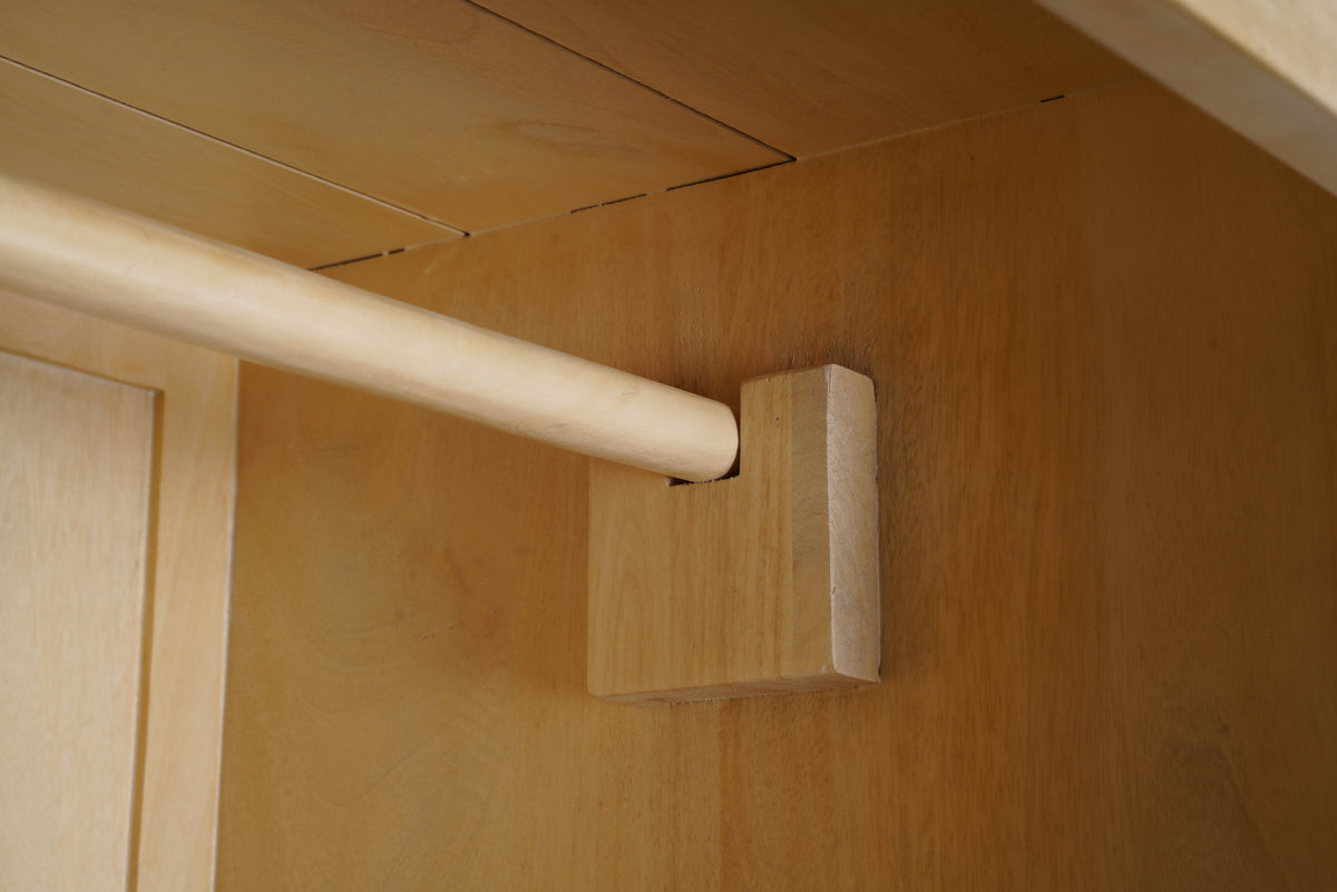 Birch armoire interior, close-up of wooden hanging rod and bracket