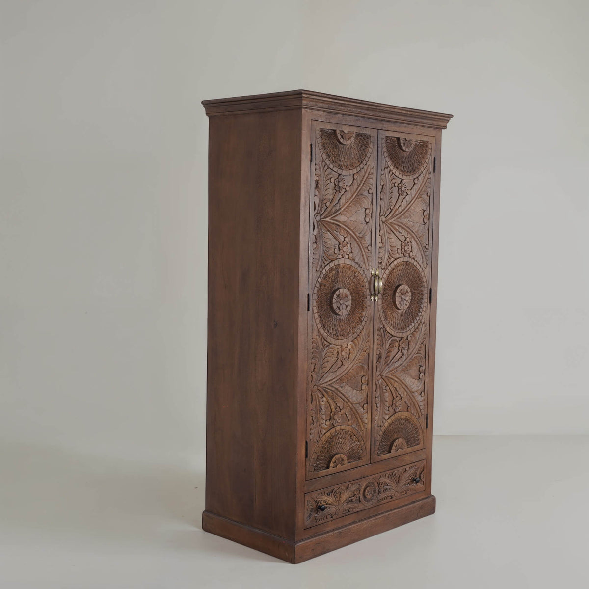 Sienna hand-carved mango wood armoire, angled studio view of carved doors